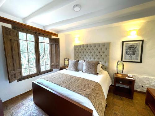 a bedroom with a large bed and a large window at Hotel Casa Terra in Villa de Leyva