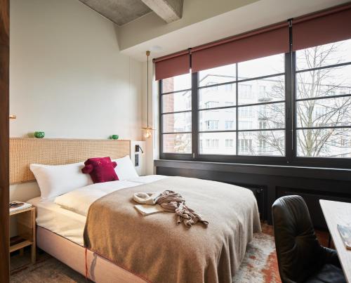 um quarto com uma cama grande e uma janela grande em hood house em Hamburgo