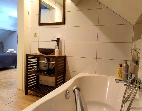 a bathroom with a bath tub and a sink at Les étangs du Thioux B&B in Malmedy