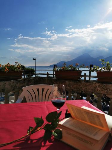 a table with a book and a glass of wine at Garda Family House in Brenzone sul Garda
