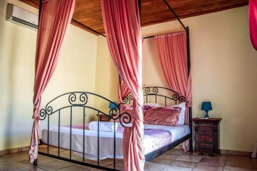 een slaapkamer met een bed met rode gordijnen bij Niriides Villas in Chersonissos