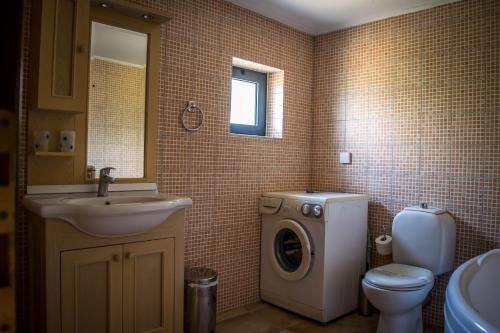 a bathroom with a washing machine and a sink at Niriides Villas in Hersonissos