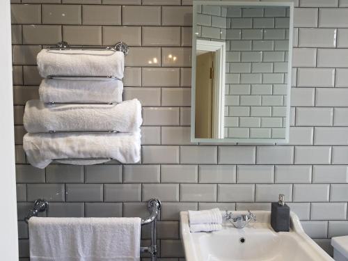 y baño con lavabo, espejo y toallas. en Afallon Townhouse Gwynedd Room en Dolgellau
