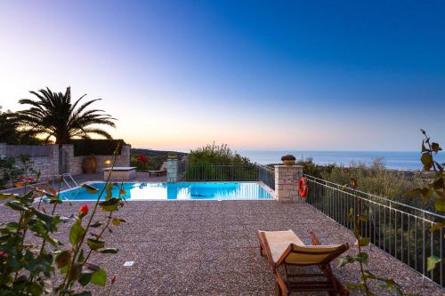 a swimming pool with a view of the ocean at Belvedere Villas in Prasiaí
