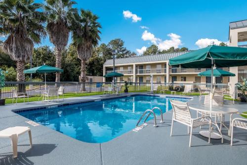 uma piscina com mesas e cadeiras e um hotel em Quality Inn Albany em Albany