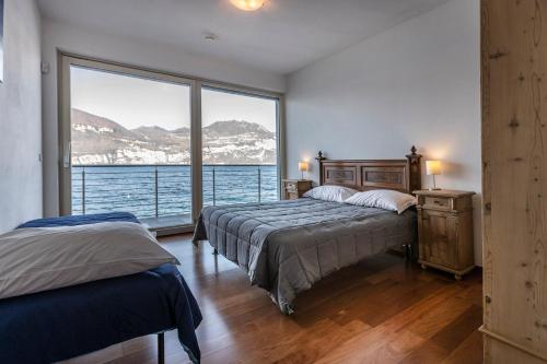 a bedroom with two beds and a large window at Villa Luthien in Brenzone sul Garda