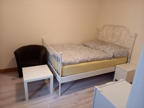 1 dormitorio pequeño con 1 cama y 1 silla en Monteurzimmer Lützow, en Lübeck