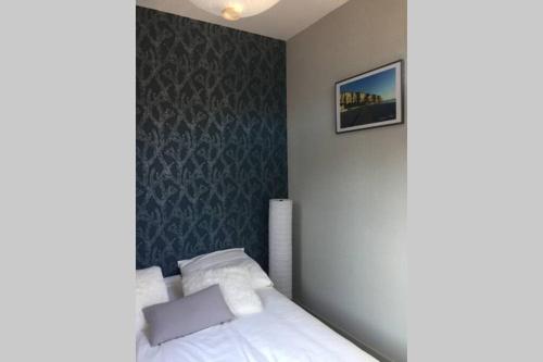 une chambre avec un lit et un tableau au mur dans l'établissement LE FORT DU TREPORT, au Tréport