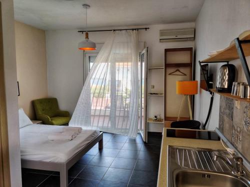 a living room with a bed and a kitchen at Lofos Vourvourou in Vourvourou