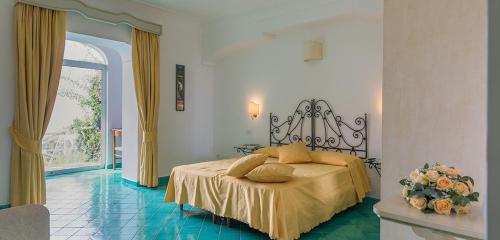 a bedroom with a bed and a vase of flowers at Bacio del Sole B&B Positano in Positano