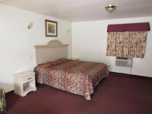 a hotel room with a bed and a window at Tropico Motel in Glendale