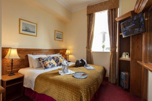 a hotel room with a bed and a television at Scholars Townhouse Hotel in Drogheda