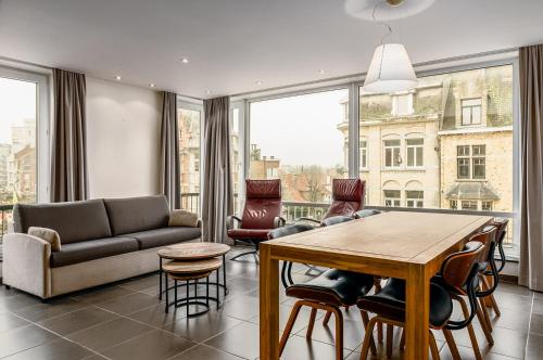 a living room with a couch and a table with chairs at Centre Leopold 204 in De Panne