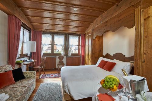 una camera d'albergo con un letto e un tavolo con frutta di Hotel Bellevue Suites & Spa a Cortina dʼAmpezzo