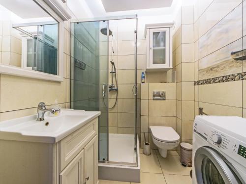 uma casa de banho com um lavatório e um WC. em Nadmorski apartament w lesie em Jantar