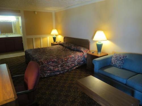 a hotel room with a bed and a couch at Executive Inn Wichita in Wichita