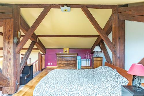 sypialnia z łóżkiem i drewnianymi belkami stropowymi w obiekcie Pléiade w Béziers