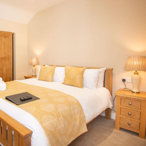 a bedroom with a large bed and two lamps at Lastra Farm Hotel in Amlwch