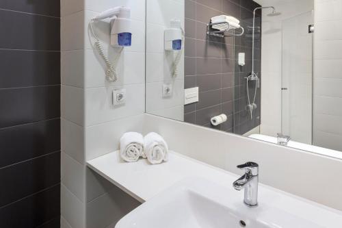 a bathroom with a sink and a mirror at B&B Hotel Barcelona Viladecans in Viladecáns