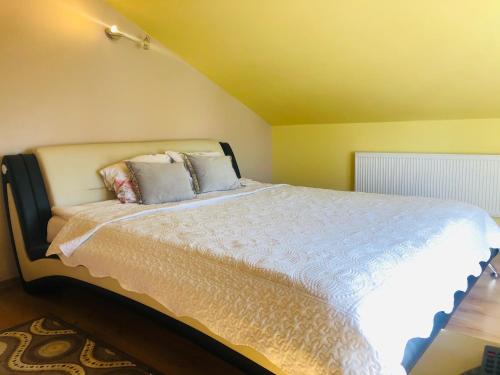a bedroom with a large bed with white sheets and pillows at Vila Romantika in Palanga