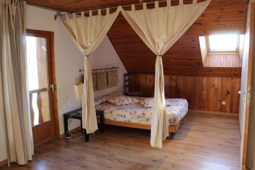 a bedroom with a bed with drapes in a cabin at Chambres d 'hôtes "Au vieux Préssoir" in Belley