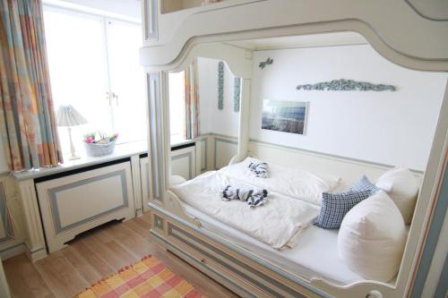un letto bianco in una stanza con finestra di Ferienwohnung Kleine Düne a Westerland