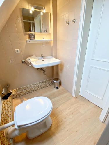 a bathroom with a white toilet and a sink at Ferienwohnung Annika 2 in Tinnum
