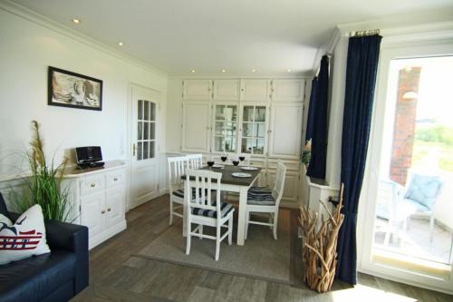 una cucina e una sala da pranzo con tavolo e sedie di Käpt`n Hörnchen a Hörnum