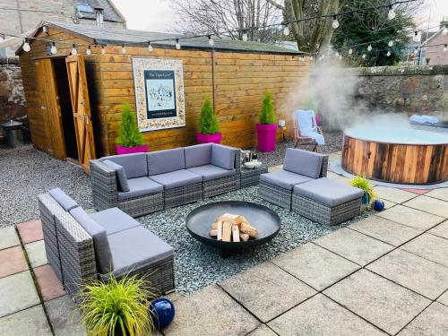 a patio with couches and a fire pit at Lairds Lodge Inverness in Inverness