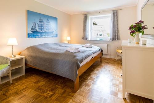 Schlafzimmer mit einem Bett und einem Fenster in der Unterkunft Haus Seeblick I in Glücksburg