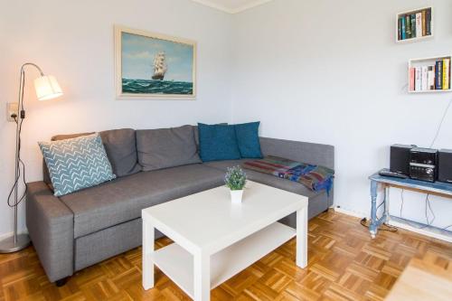 a living room with a couch and a table at Ferienhaus Seeblick - gemütliche 60qm - 50m zum Naturstrand - mit Terrasse und großem Garten in Glücksburg
