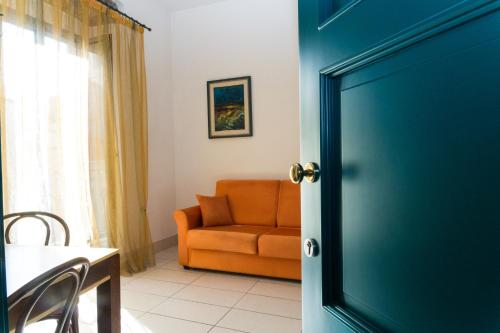 an orange chair and a couch in a room at Le dimore Al Vecchio Teatro in Ortona