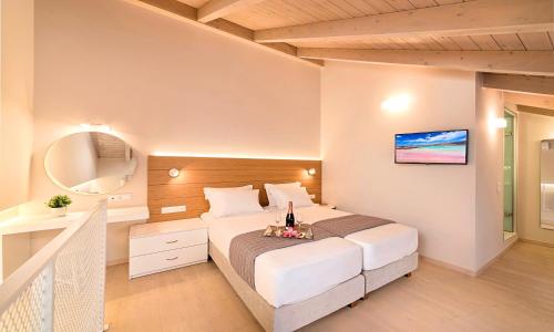 Pal Calma Suites في مدينة ريثيمنو: غرفة نوم بسرير كبير ومرآة