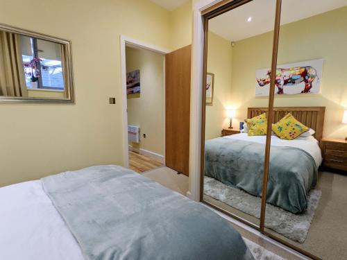 a bedroom with a mirror next to a bed at Heart of the City - FREE PARKING in York