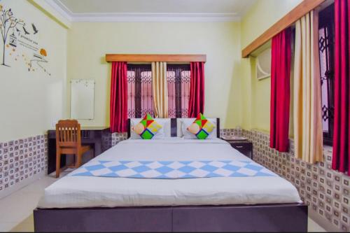 コルカタにあるHoliday Rental Roomsのベッドルーム1室(赤いカーテン付きの大型ベッド1台付)