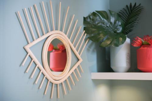 a small pink mirror with a potted plant on a shelf at MiHotel Gailleton in Lyon