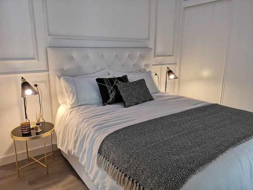 a bedroom with a large bed with two pillows on it at Casa Casiopea Elegante y exótica in Sanlúcar de Guadiana