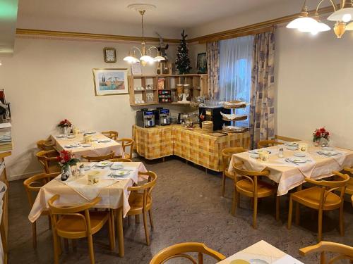 ein Restaurant mit Tischen und Stühlen in einem Zimmer in der Unterkunft Pension - Alt - Strassgang in Graz