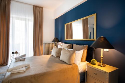 a bedroom with a large bed with a mirror on the wall at Metropole Apartments Studio Old City in Bucharest
