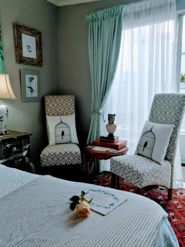 a bedroom with a bed and two chairs and a window at The Place Guesthouse Parys in Parys