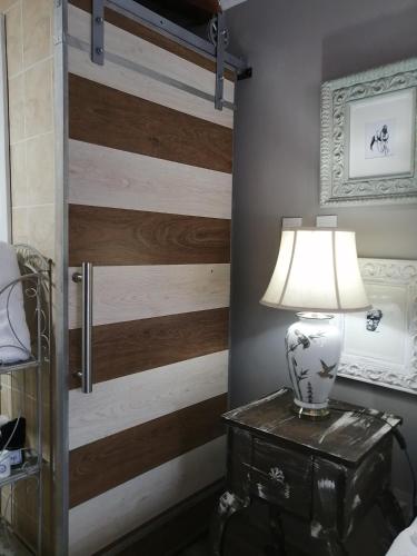 a lamp on a table next to a wooden door at The Place Guesthouse Parys in Parys