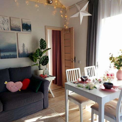 a living room with a couch and a table at Brīvdienu māja ar Saunu in Saulkrasti