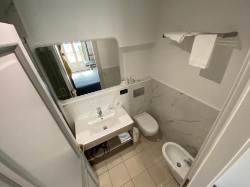 a bathroom with a sink and a toilet and a mirror at Artua'&Solferino in Turin