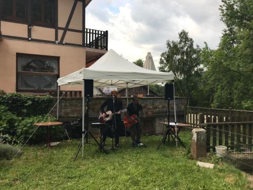 two musicians under a tent in a yard at Chambre double dans Auberge Alsacienne in Scherwiller
