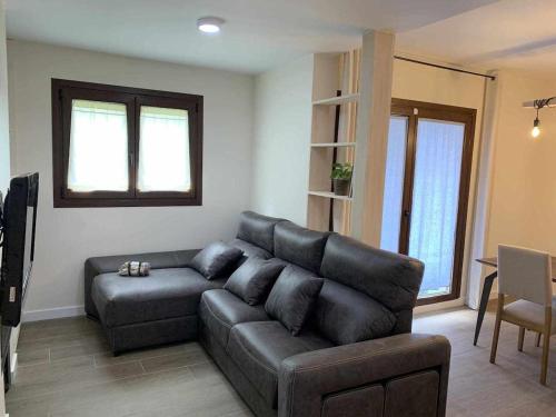sala de estar con sofá negro y mesa en Casa Cotefablo Alojamiento Ara Gavin Biescas, en Gavín