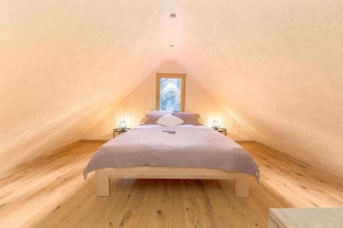 ボーヒニにあるBohinj Cottage Pr' Maricki - house in nature with hot tub & saunaのベッドルーム1室(屋根裏部屋に大型ベッド1台付)
