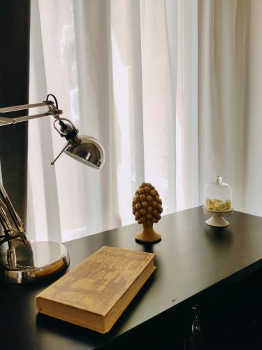a book on a desk with a lamp and a candle at Il Meraviglioso Mondo di Amélie in Agrigento