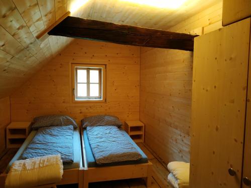 a room with two beds in a wooden cabin at Alp Es-Cha Dadour in Madulain