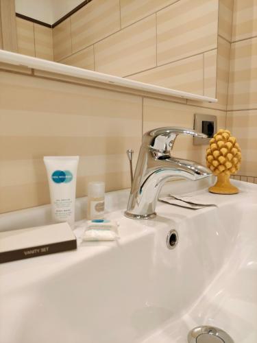 a bathroom sink with a faucet and other items on it at Il Meraviglioso Mondo di Amélie in Agrigento