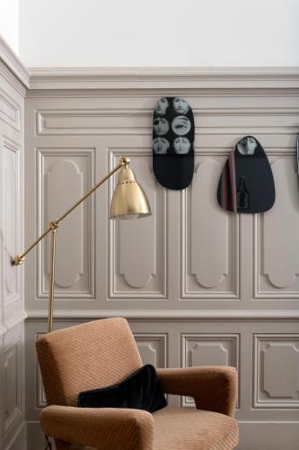 a living room with a chair and a lamp at MiHotel Gailleton in Lyon